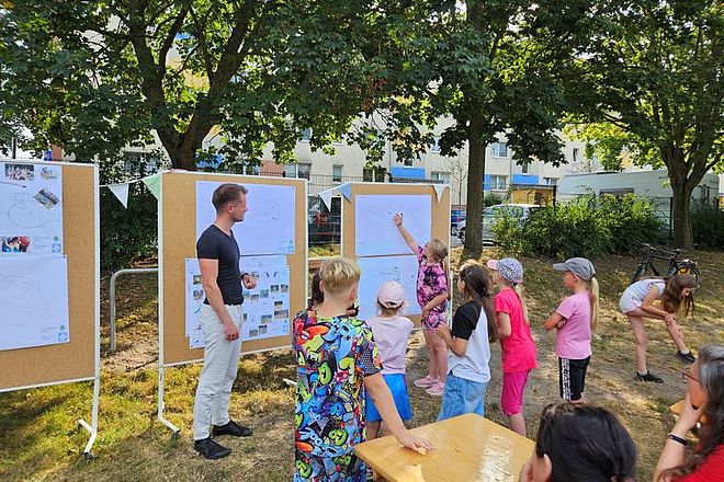 Bild zeigt Kinder die ihre Ideen an eine Aufstellwand pinnen