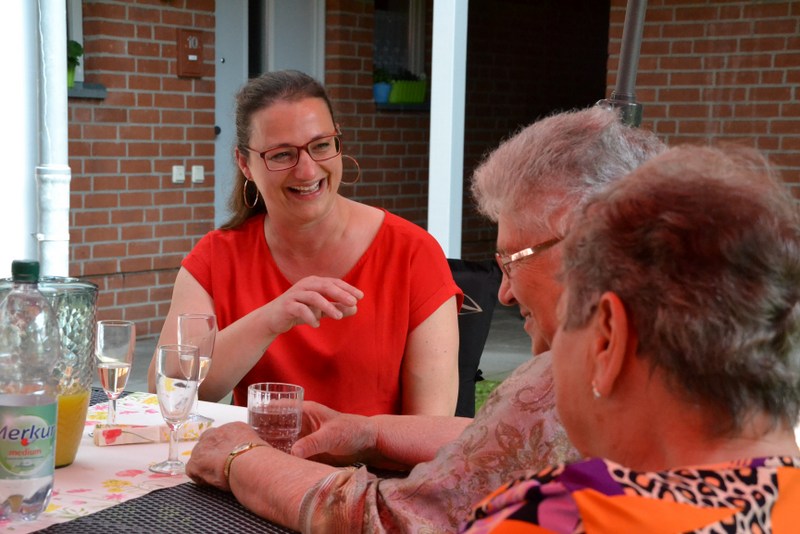 Bild zeigt Jenny Mendonça im Gespräch mit zwei Bewohnerinnen an einem Tisch