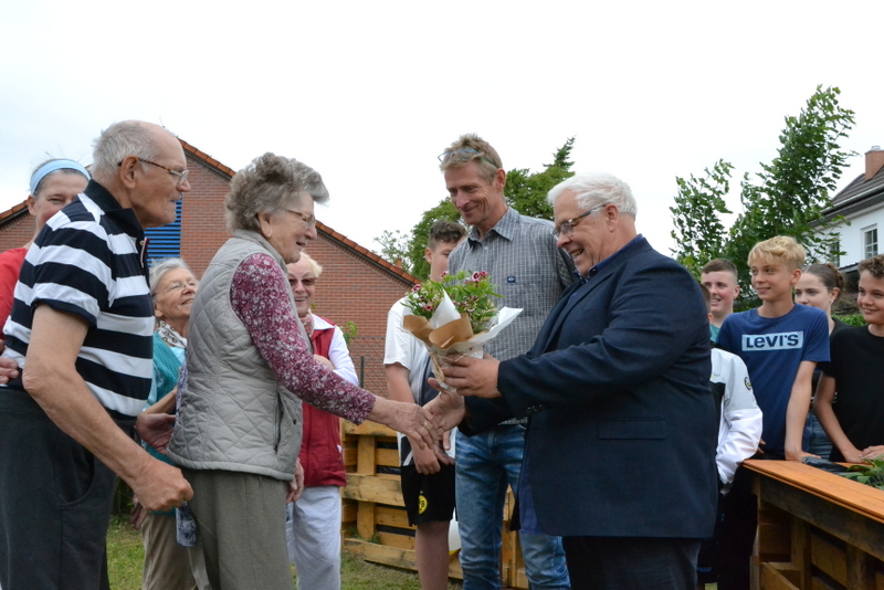 Bild zeigt den Bürgermeister Stiewe beim überreichen eines Blumengrußes
